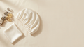 Ivory pure mulberry silk sleep bonnet on a warm cream background with eucalyptus